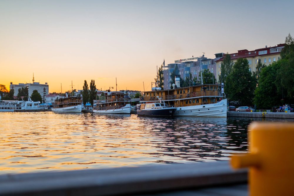 Boats docked at the harbour of Savonlinna, Finland, during a colourful sunset.