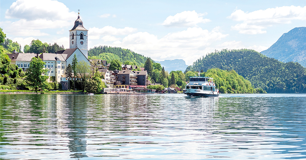 Ferry cruising on Wolfgangsee with a picturesque village in the background.