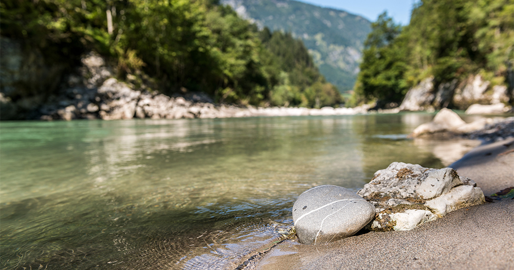 Tranquil river flowing through a lush alpine valley.