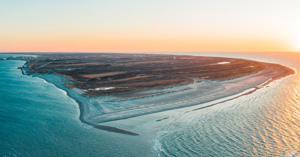 Aerial view of Grenen in Skagen, Denmark, where two seas meet at sunset.
