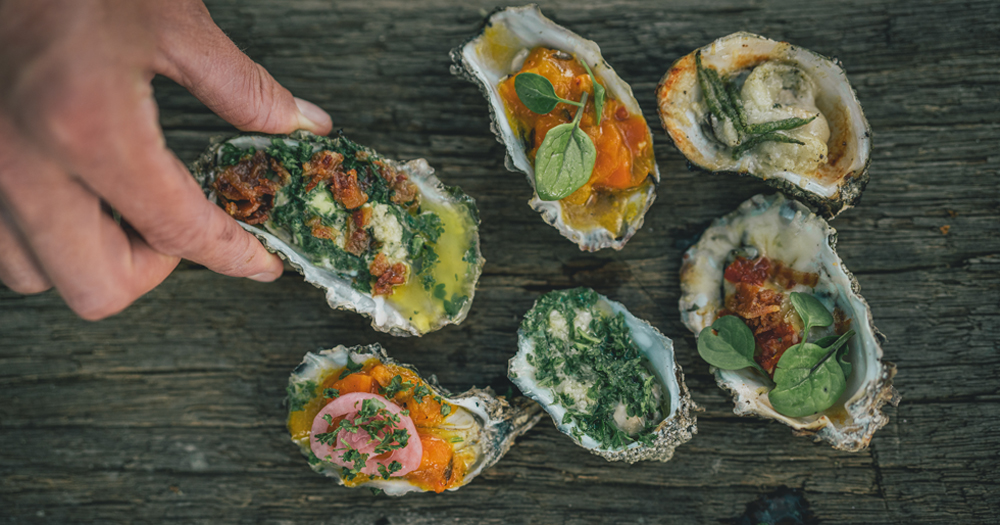 Freshly prepared oysters with herbs and toppings served by the Wadden Sea in Denmark, a local coastal delicacy.