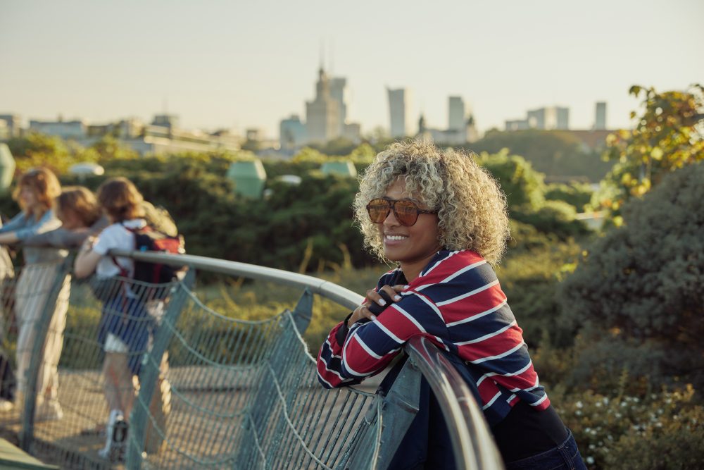 Woman enjoying the rooftop gardens in Warsaw with the modern city skyline in the background.